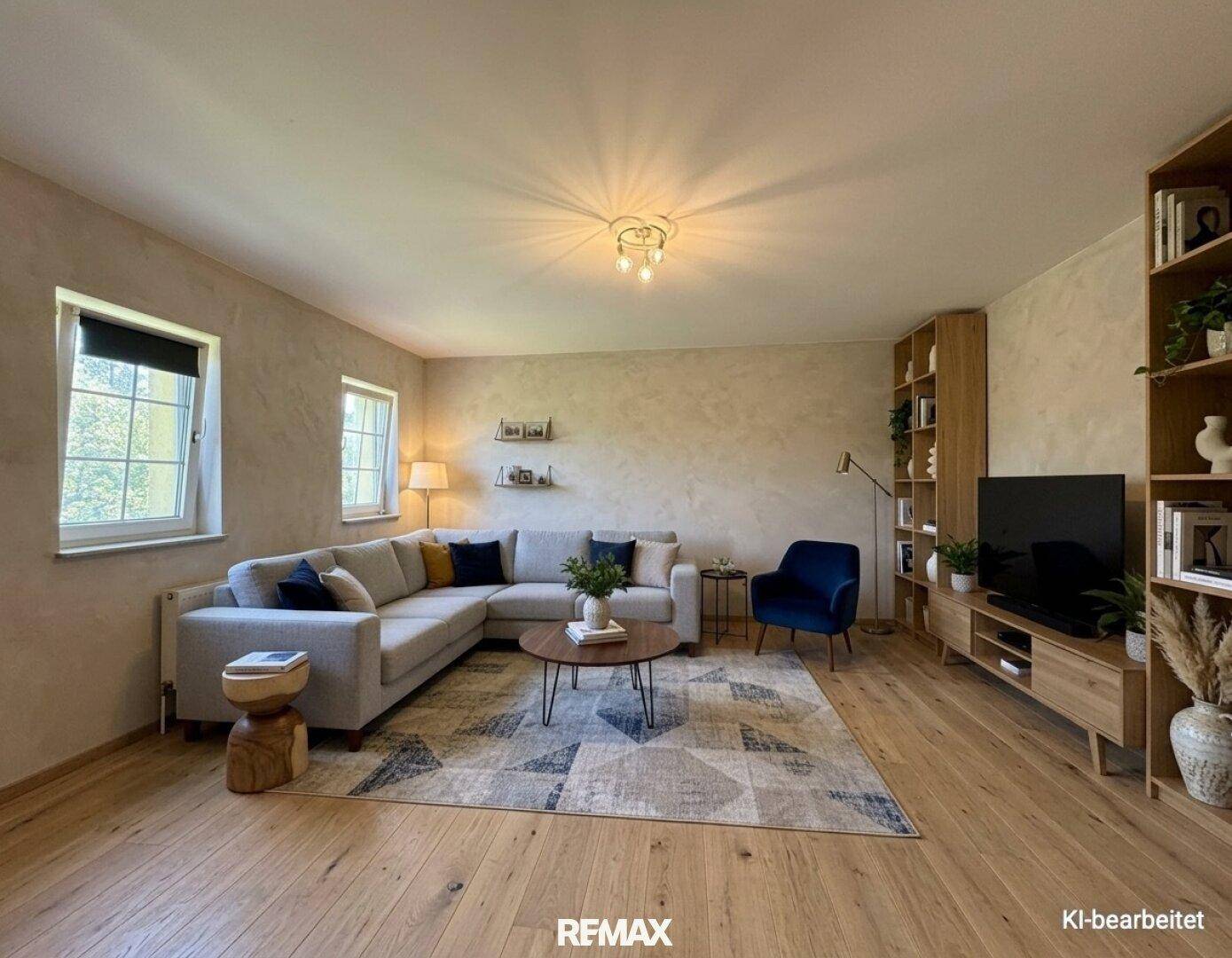 Gemütliches Wohnzimmer mit Fischgrätparkett, großem Ecksofa und Bücherregalen.