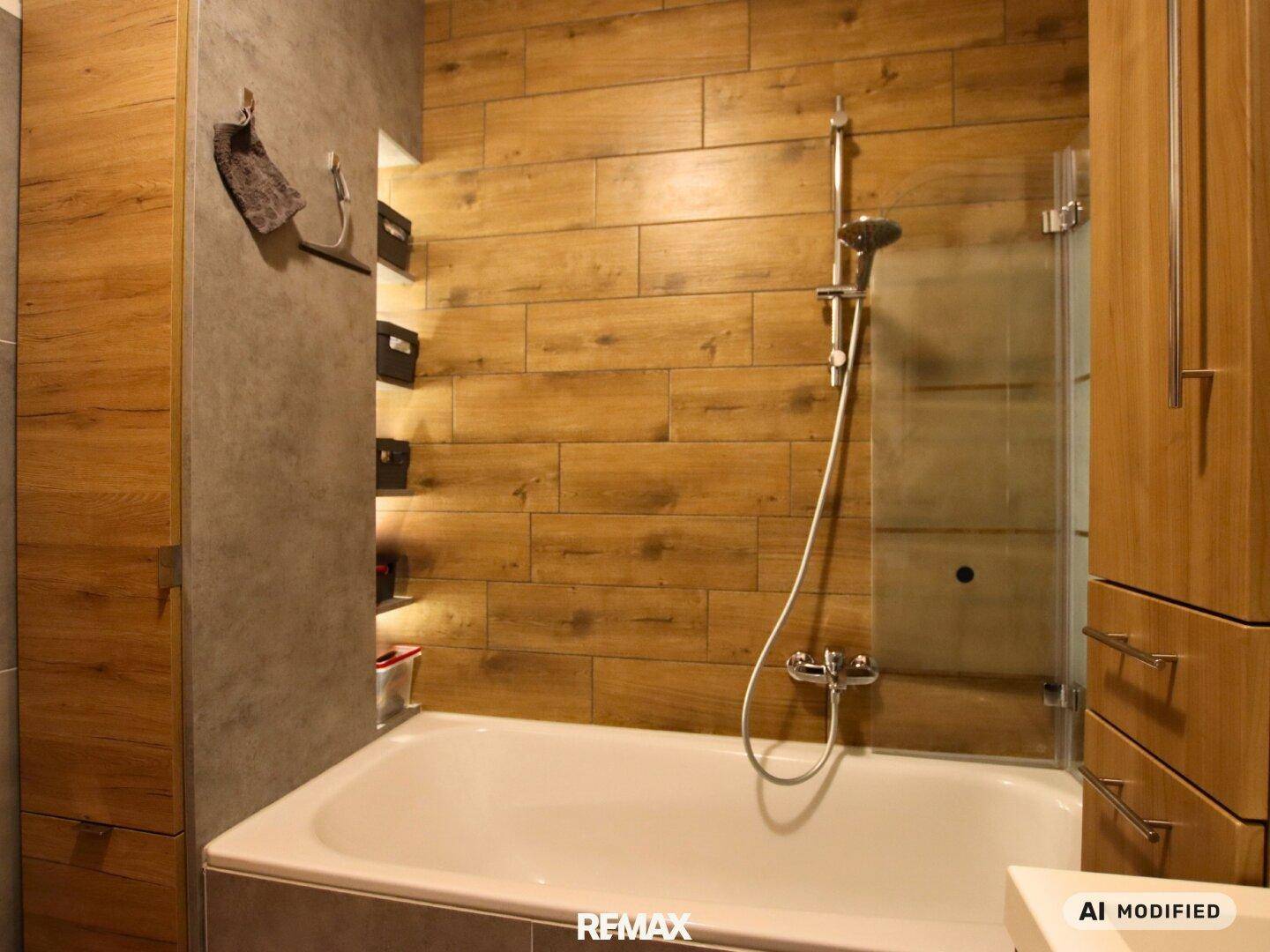 Detailansicht des Badezimmers mit Badewanne, Duscharmatur und stilvollen Holzoptik-Fliesen.