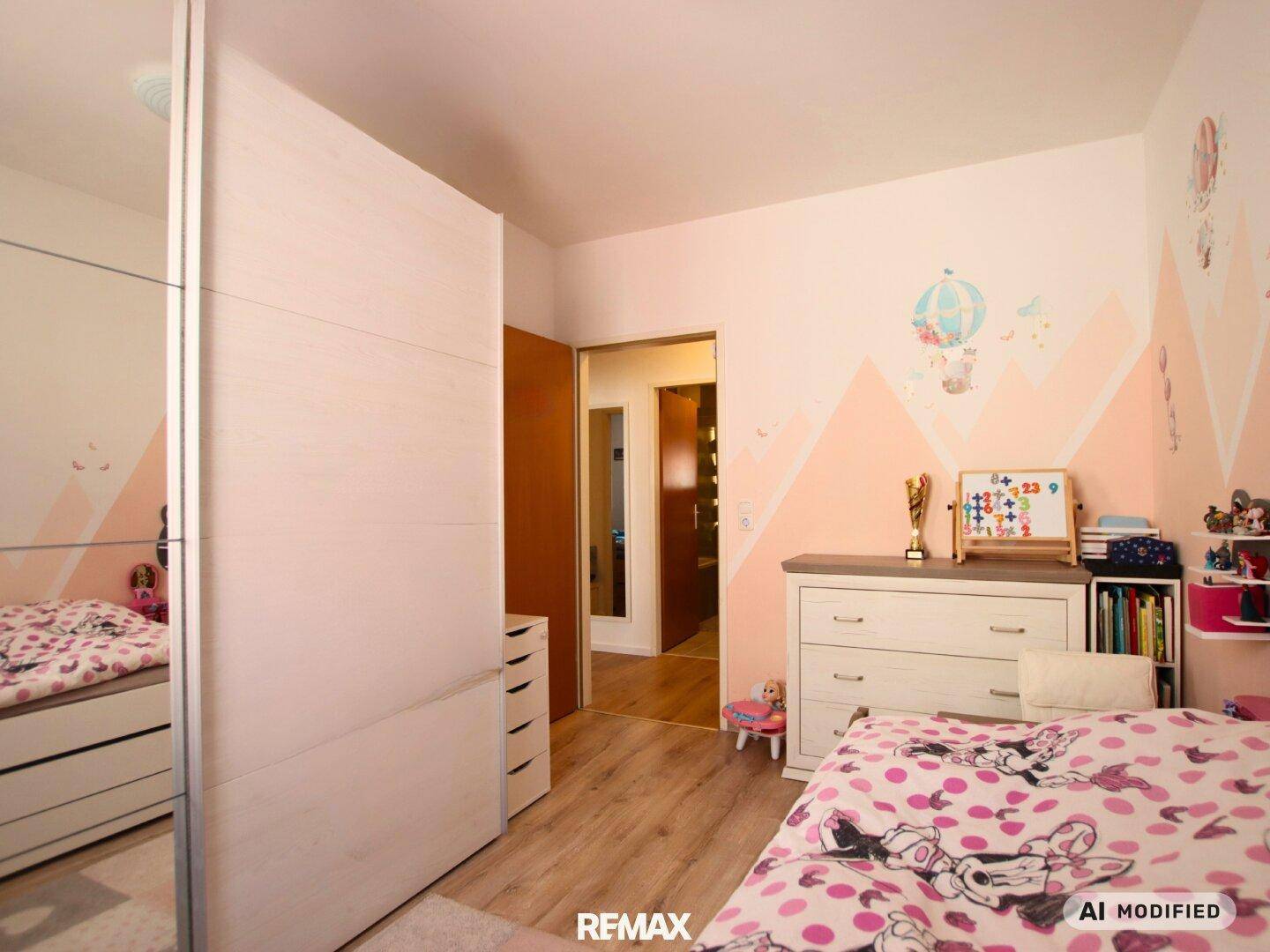 Helles Kinderzimmer mit Kleiderschrank, Kommode und liebevoller Dekoration.