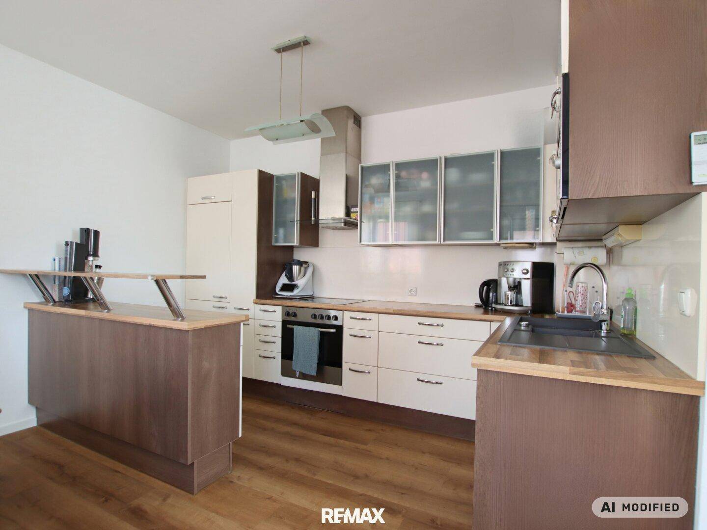 Funktionale Einbauküche mit hellen Fronten, Holzdetails und modernen Küchengeräten.