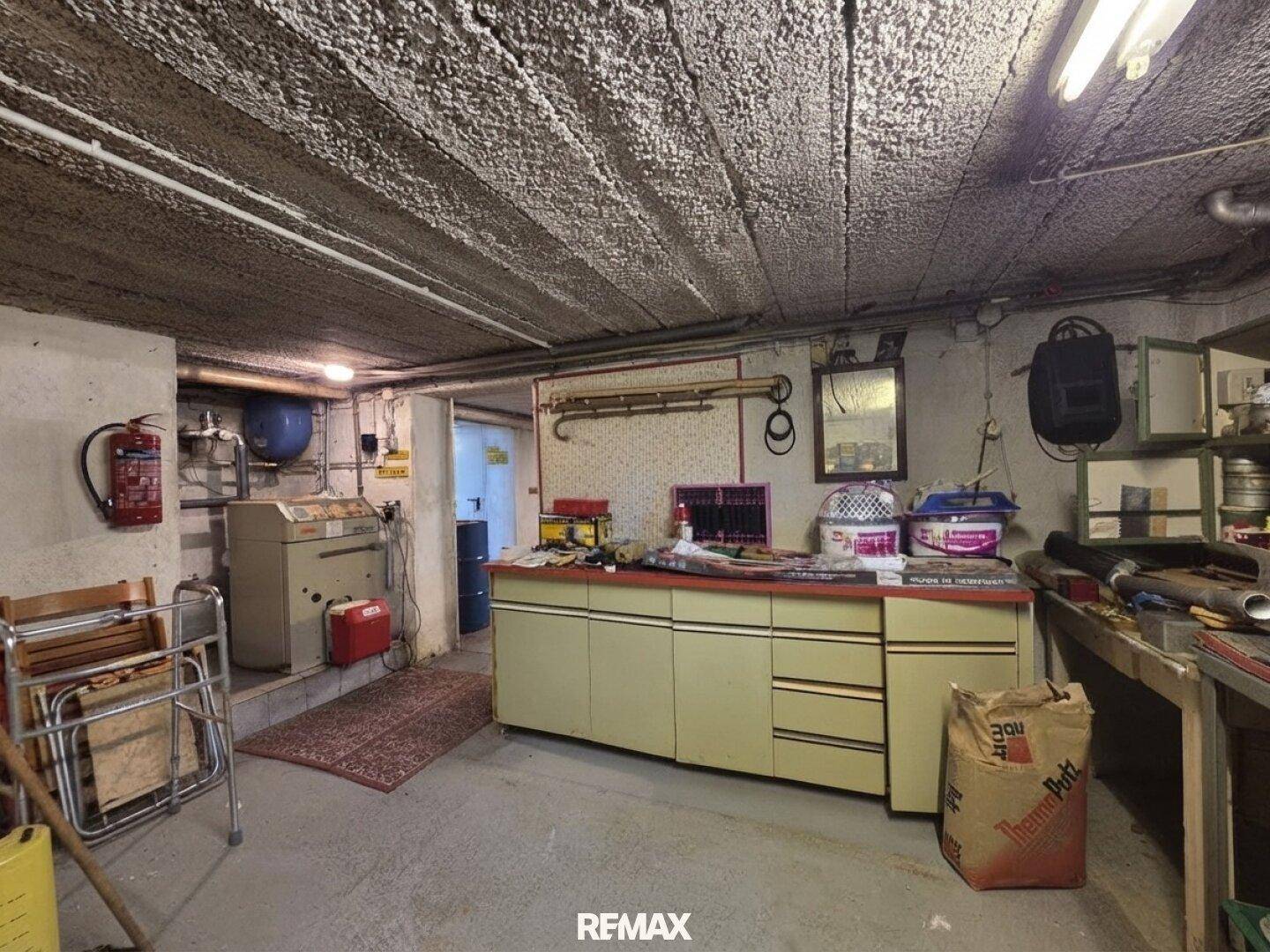 Kellerraum mit Werkbank, Lagerflächen und Heizungsanlage, ideal für Hobby und Lagerung.