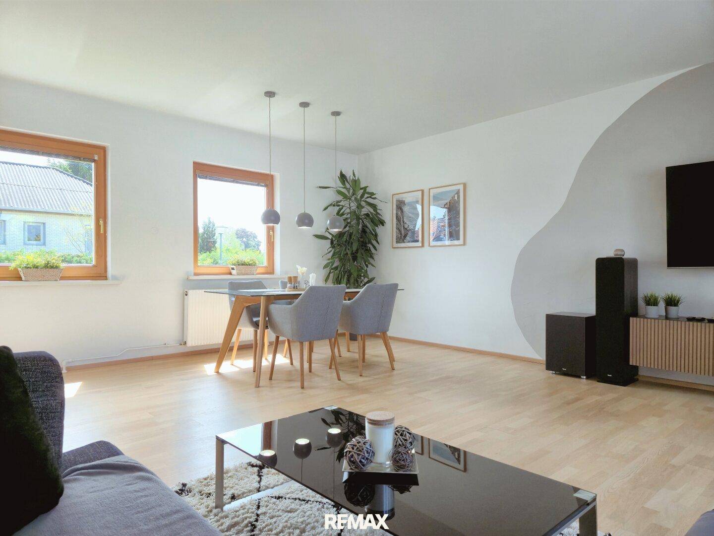 Gemütlicher Essbereich im offenen Wohnzimmer mit Holzboden und Blick ins Grüne.