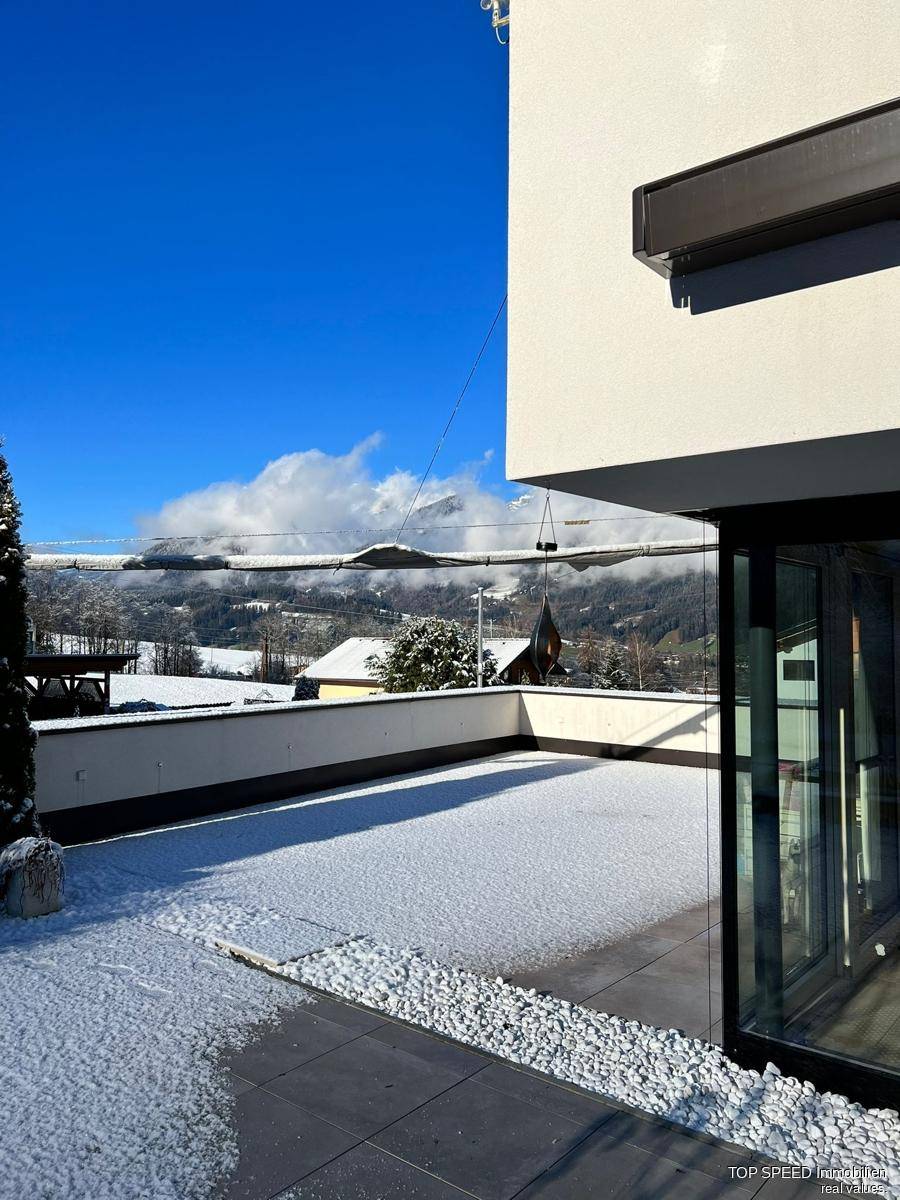 Große Terrasse mit Schnee bedeckt und weitem Blick auf die verschneite Berglandschaft.