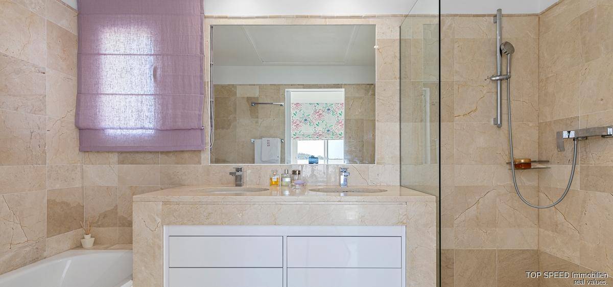 Elegantes Badezimmer mit Doppelwaschbecken, Badewanne und Duschbereich, in warmen Naturtönen gehalten.