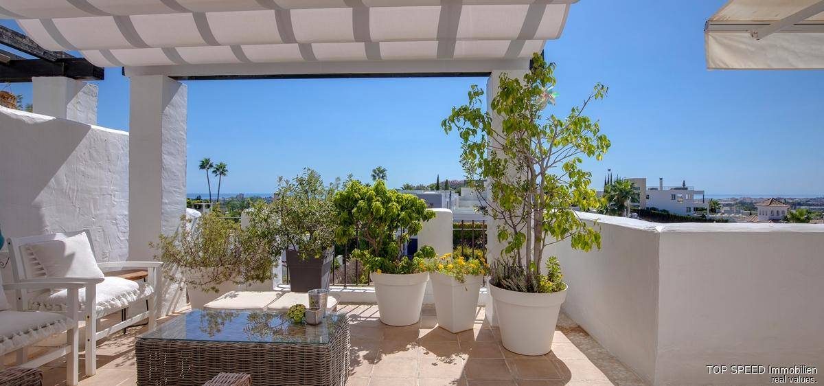 Helle Terrasse mit bequemen Sitzgelegenheiten und weitem Blick in die Landschaft.