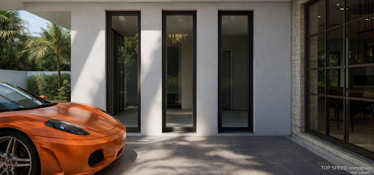 Detailansicht der modernen Fassade mit hohen Fenstern und einem orangefarbenen Sportwagen im Carportbereich.