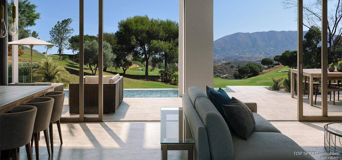Helles Wohnzimmer mit großen Glasfronten und Panoramablick auf den Pool und den Golfplatz.