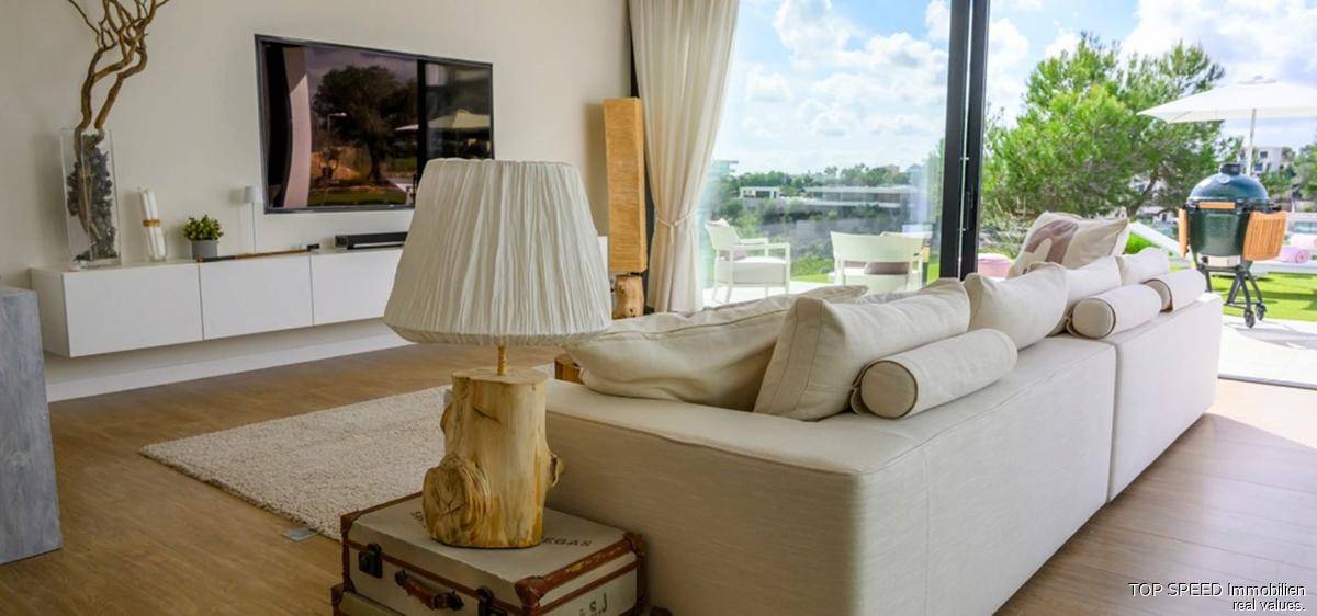 Gemütliches Wohnzimmer mit bequemen Sofas, großem Fernseher und Zugang zur Terrasse.