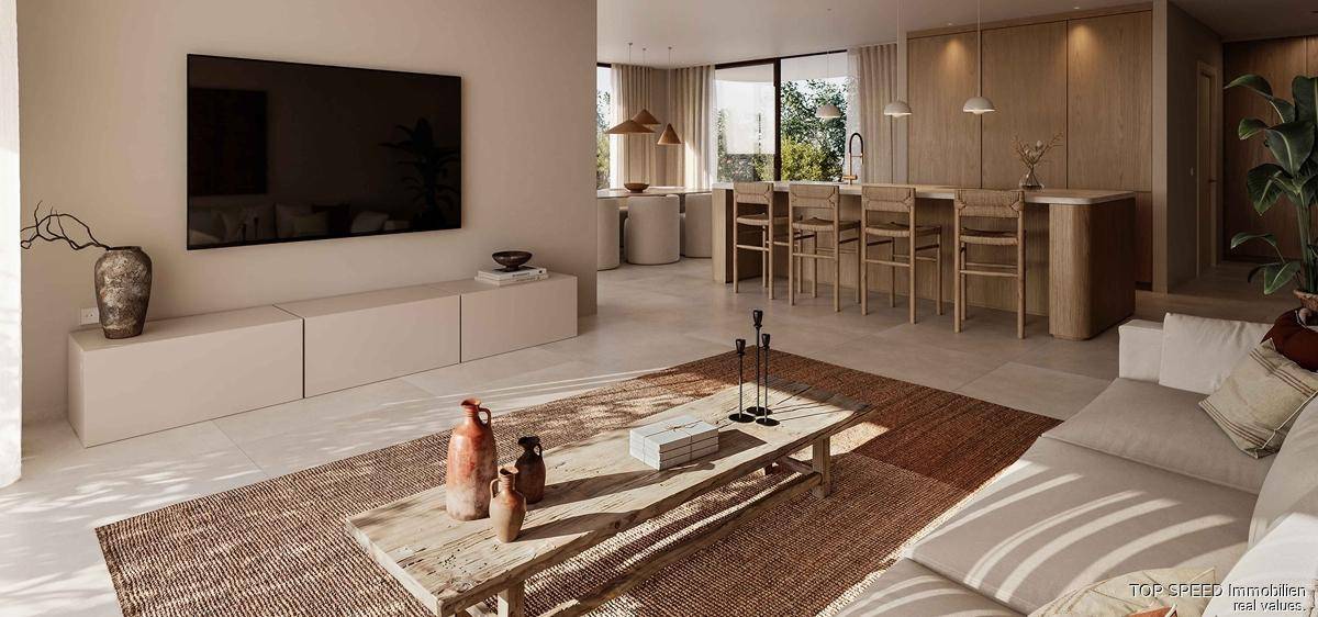 Helles Wohnzimmer mit minimalistischem Design, großem Fernseher und Blick auf den Essbereich und die Küche.