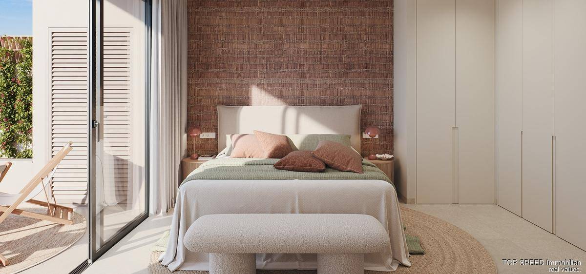 Helles Schlafzimmer mit moderner Einrichtung, Holzwand und Zugang zur Terrasse.