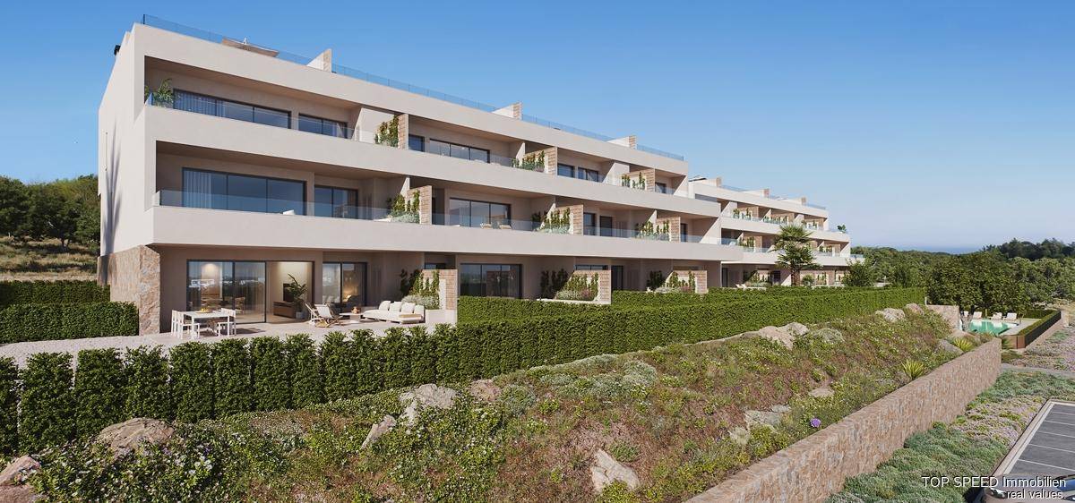 Moderne Wohnanlage mit Terrassen und gepflegten Grünflächen in sonniger Umgebung.