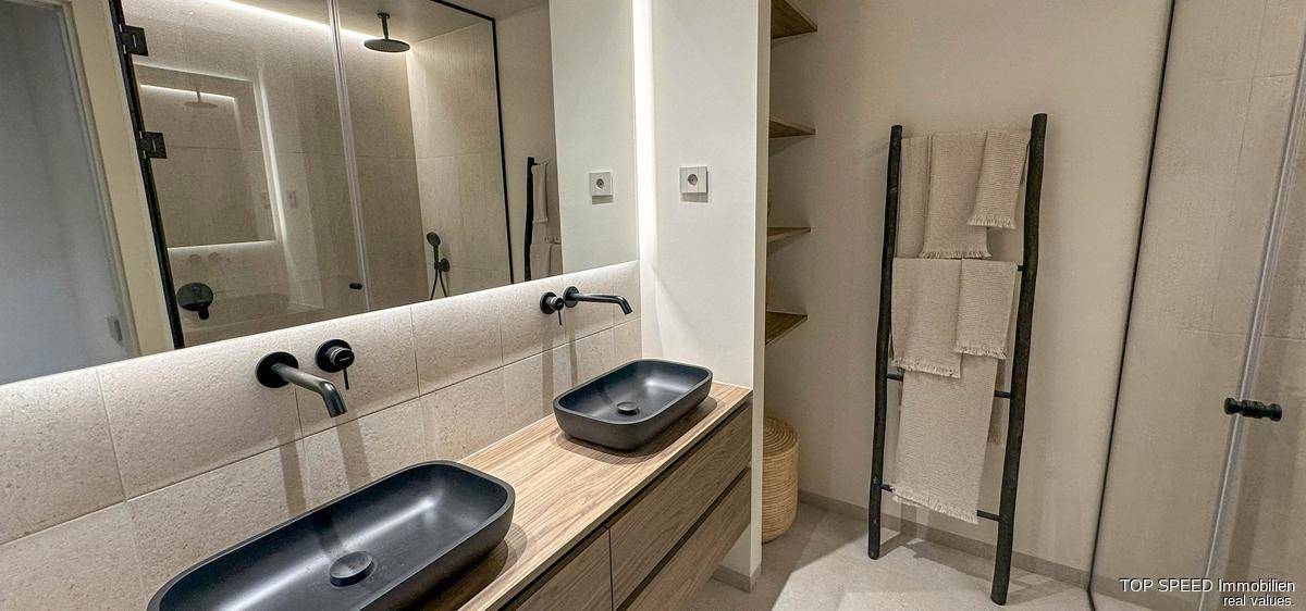 Modernes Badezimmer mit Doppelwaschbecken, großem Spiegel und begehbarer Dusche.