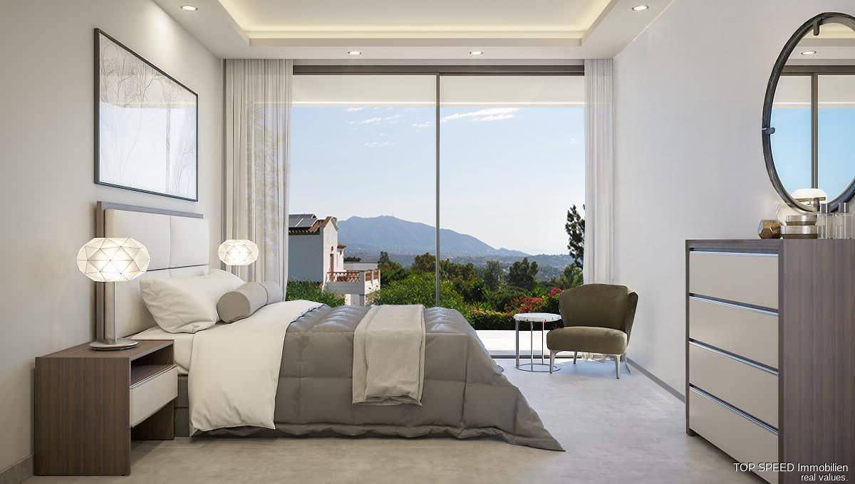 Helles Schlafzimmer mit Panoramablick auf die Berge, großen Fenstern und moderner Einrichtung.