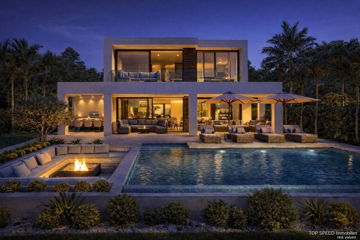 Luxuriöse Villa bei Nacht mit beleuchtetem Pool, gemütlicher Feuerstelle und stilvollen Außenbereichen.