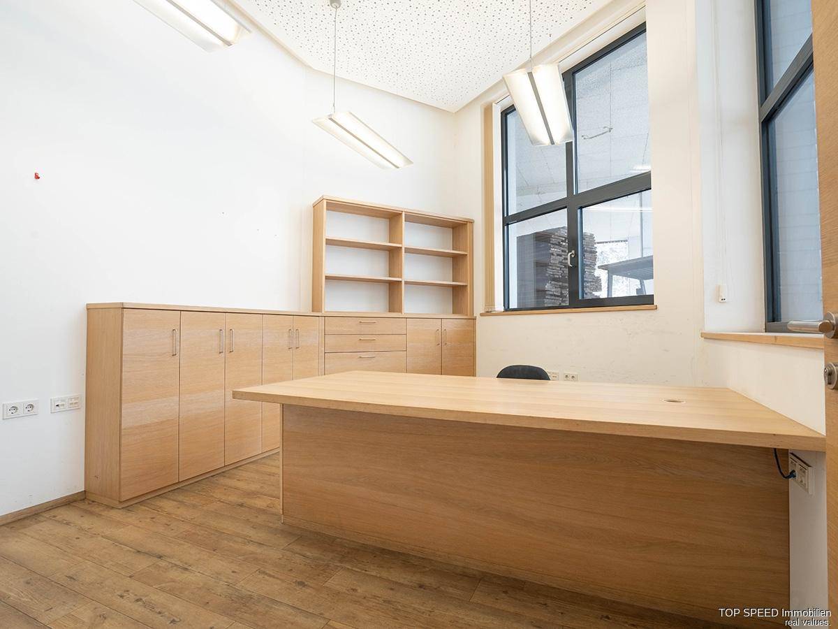 Geräumiges Büro mit Holzboden, großem Schreibtisch und Holzschränken, ideal für produktives Arbeiten.