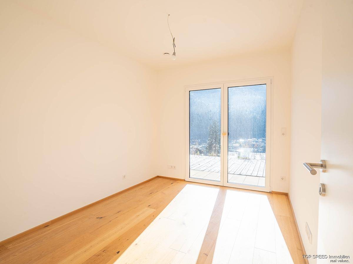 Lichtdurchflutetes Schlafzimmer mit Holzboden und direktem Zugang zu einem Außenbereich.