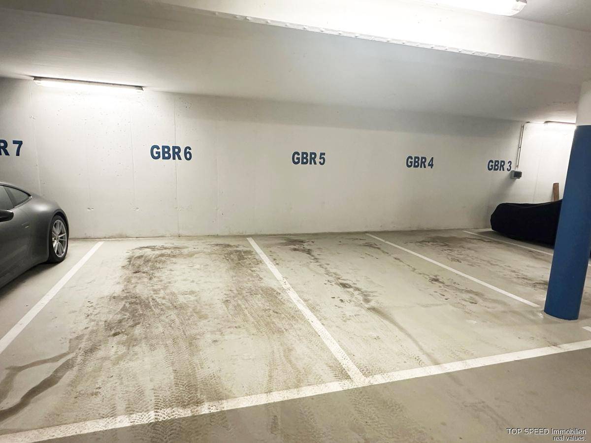 Saubere und ordentliche Tiefgarage mit leeren Stellplätzen und klarer Beschilderung.