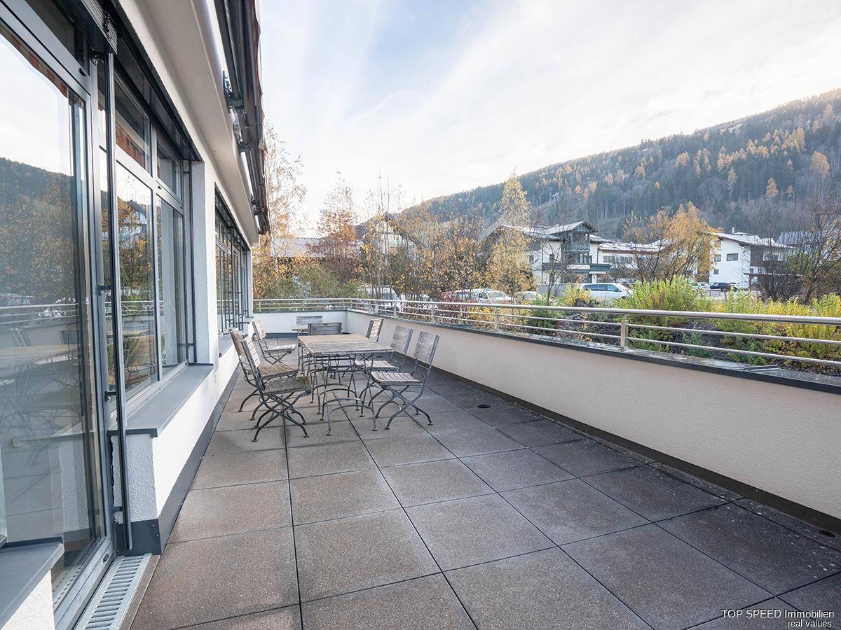 Geräumige Außenterrasse mit Sitzgelegenheiten und weitem Blick auf die umliegende Berglandschaft.
