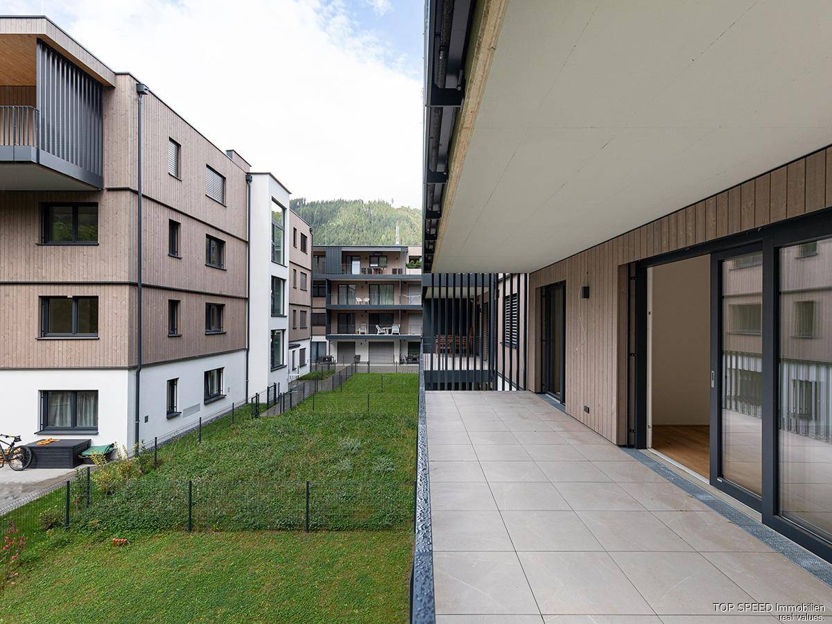 Moderner Gebäudekomplex mit Holzfassade und großzügigen Balkonen mit Blick auf die Umgebung.