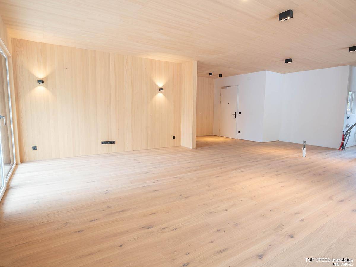 Heller, geräumiger Raum mit Holzvertäfelung an Wänden und Decke sowie hellem Holzplankenboden.