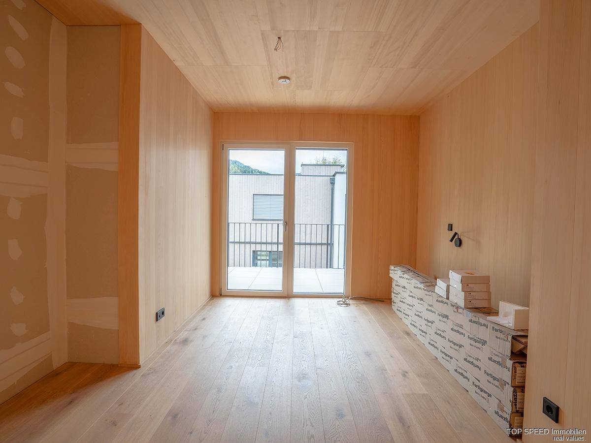 Geräumiges Schlafzimmer mit Holzboden und Balkonzugang, bereit für die individuelle Gestaltung.