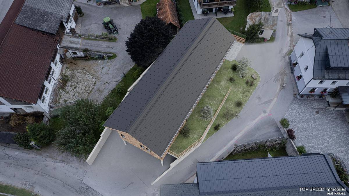 Dachansicht des modernen Gebäudes mit Satteldach und der grünen Umgebung, umgeben von Natur.
