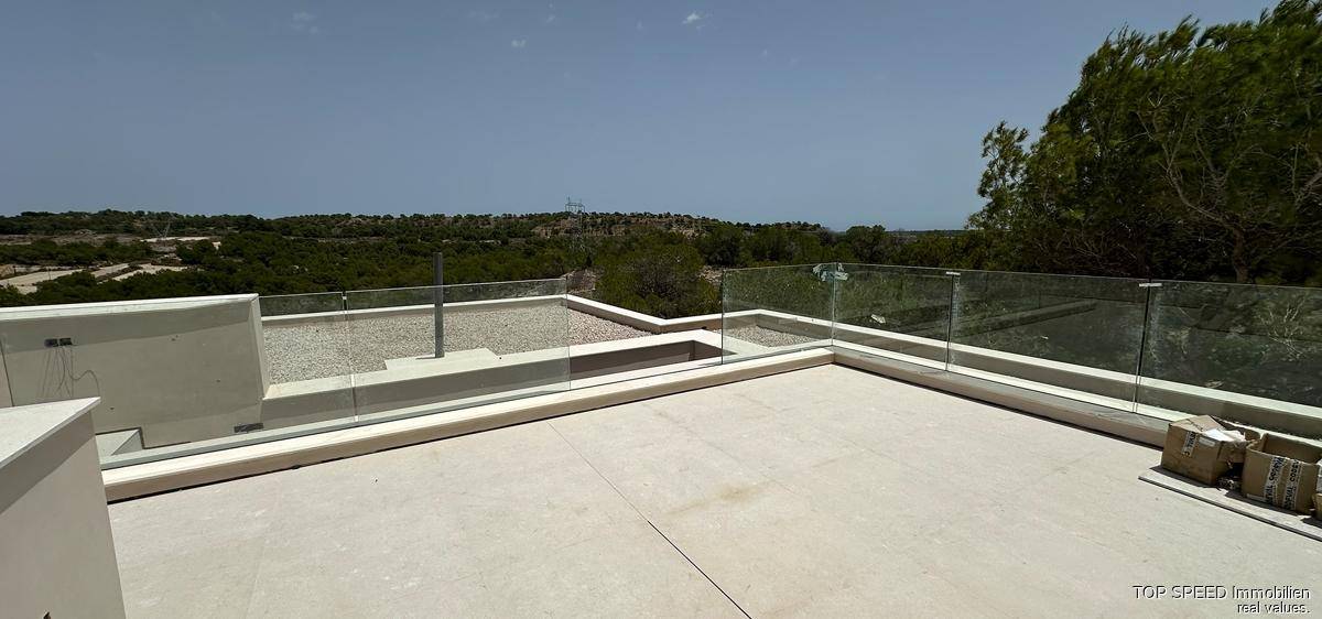 Dachterrasse im Bau mit Glasgeländer und weitem Blick über die grüne Landschaft.