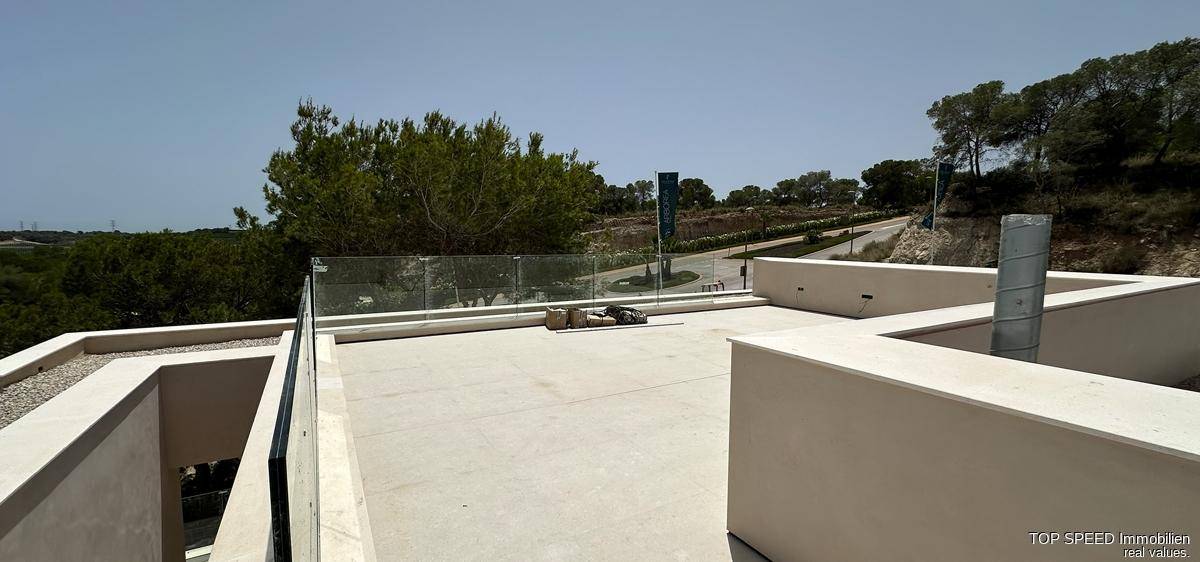 Weitläufige Dachterrasse im Bau mit Glasgeländer und Panoramablick auf die Umgebung.