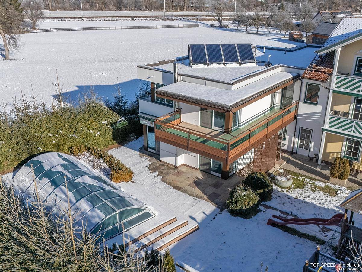 Luftaufnahme des Anwesens mit Pool, Solarpaneelen und verschneiter Landschaft.