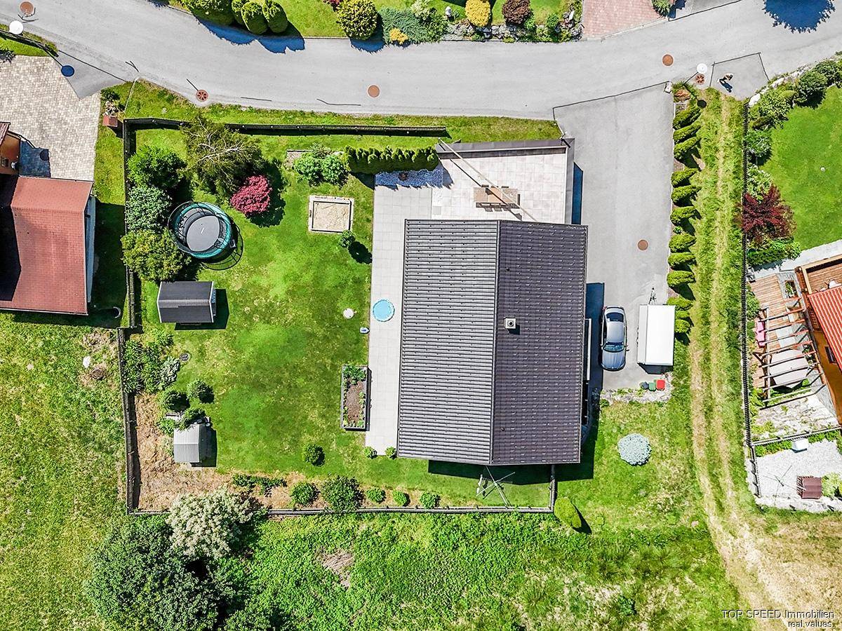 Luftaufnahme des Grundstücks mit Haus, großem Garten, Terrasse und Zufahrt in ländlicher Umgebung.