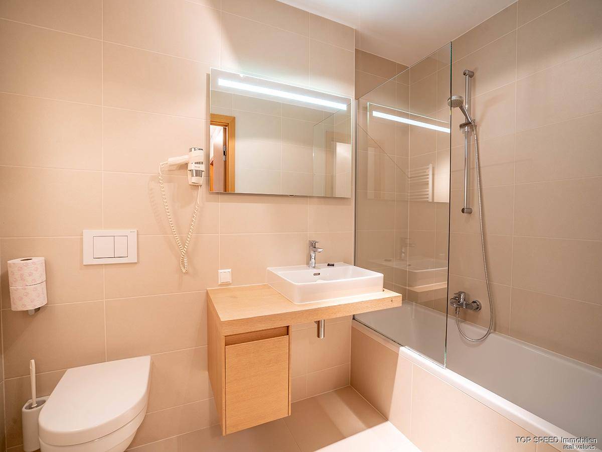 Modernes Badezimmer mit Badewanne, Dusche, WC und einem einzelnen Waschbecken.