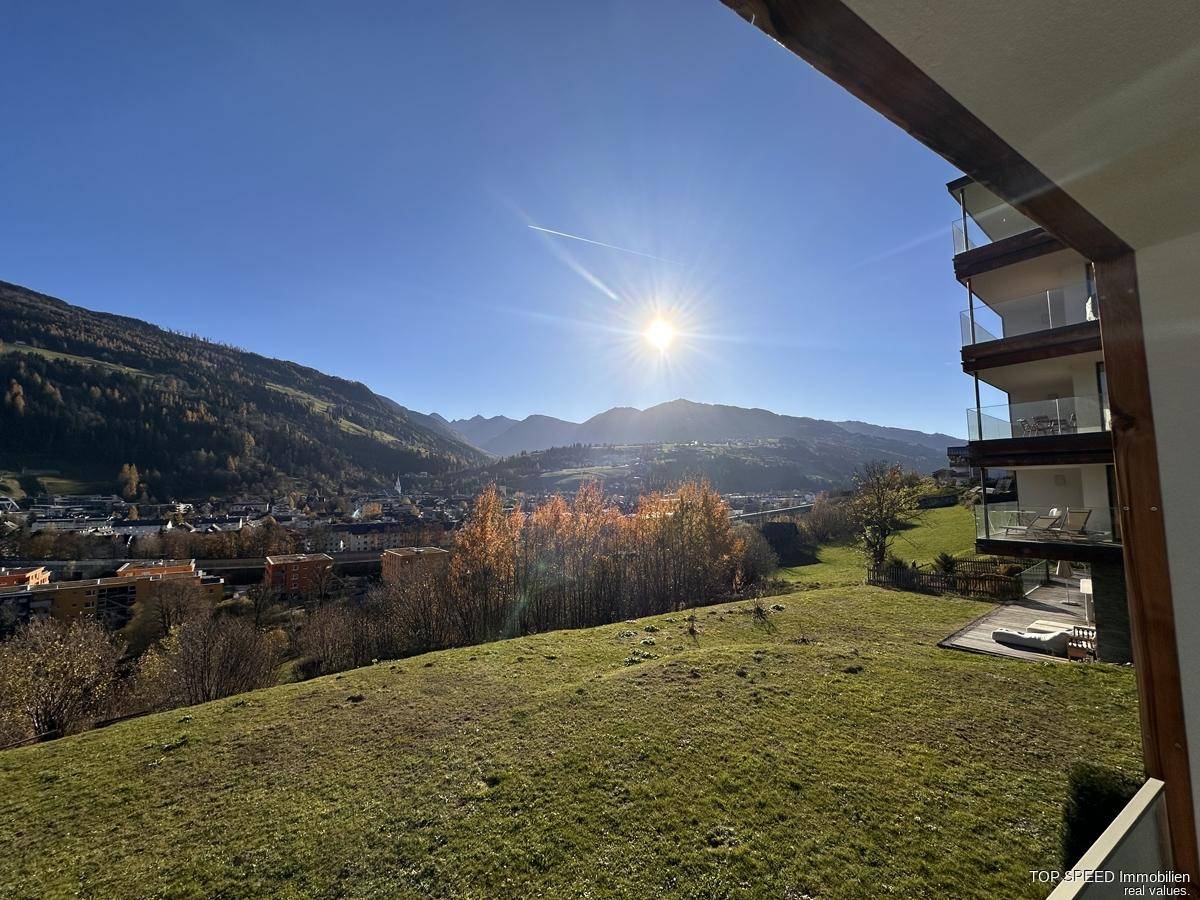 Sonniger Ausblick auf die Berge und grüne Hügel von einem Balkon oder einer Terrasse.