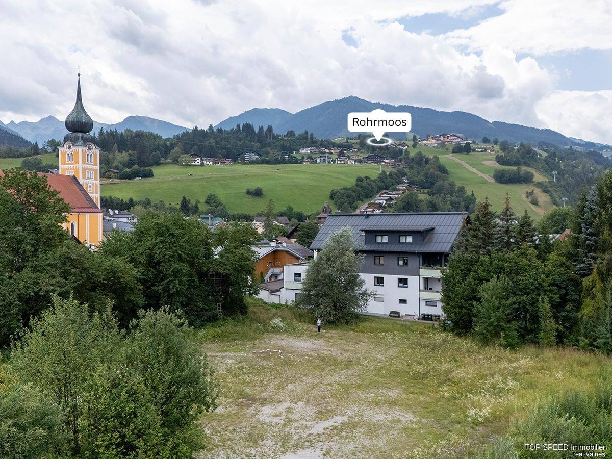 Panoramablick auf die ländliche Umgebung mit Kirche, Bergen und dem Ort Rohrmoos.