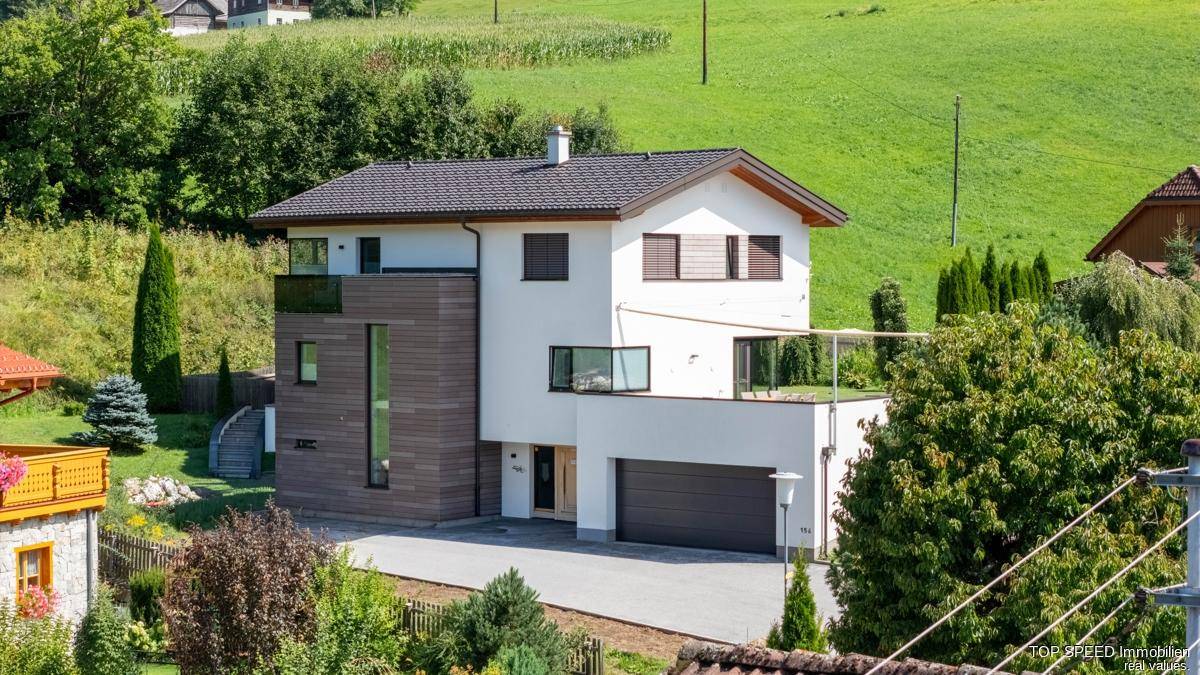 Ansicht des modernen Einfamilienhauses mit Garage und einer großzügigen Terrasse mit Weitblick.