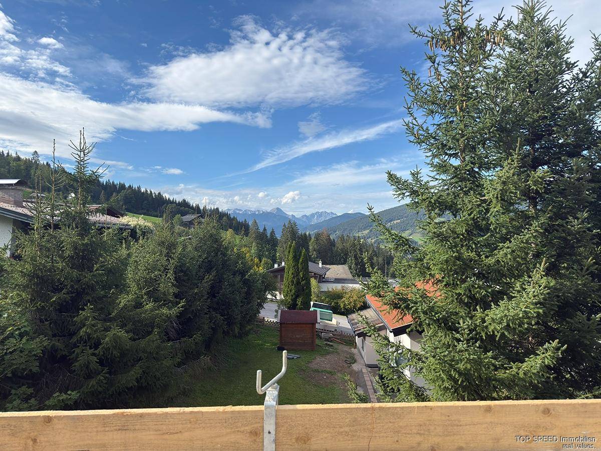 Weitläufiger Blick über bewaldete Hügel und entfernte Berge an einem sonnigen Tag.