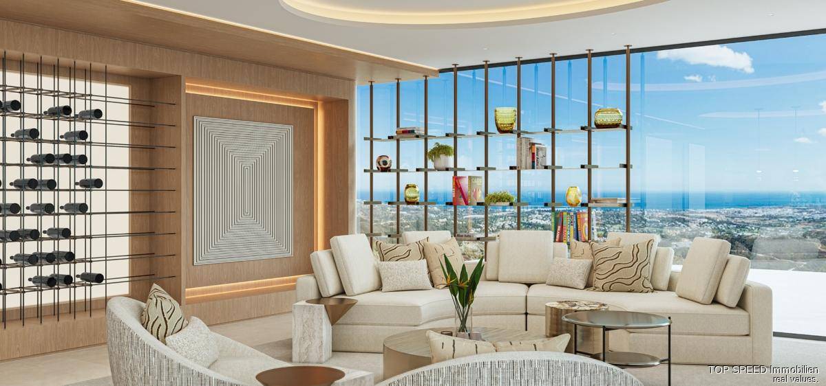 Helles Wohnzimmer mit raumhohen Fenstern, Weinregal und Stadtblick.