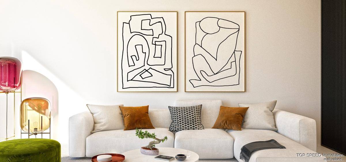 Helles Wohnzimmer mit weißer Couch, abstrakter Kunst und farbigen Akzenten.