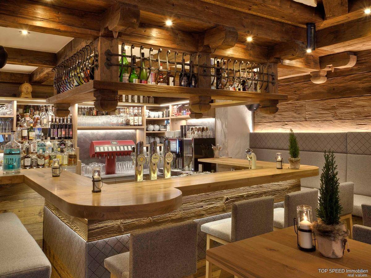 Gut ausgestattete Holzbar mit Zapfanlage, Flaschenregalen und rustikalem Design.