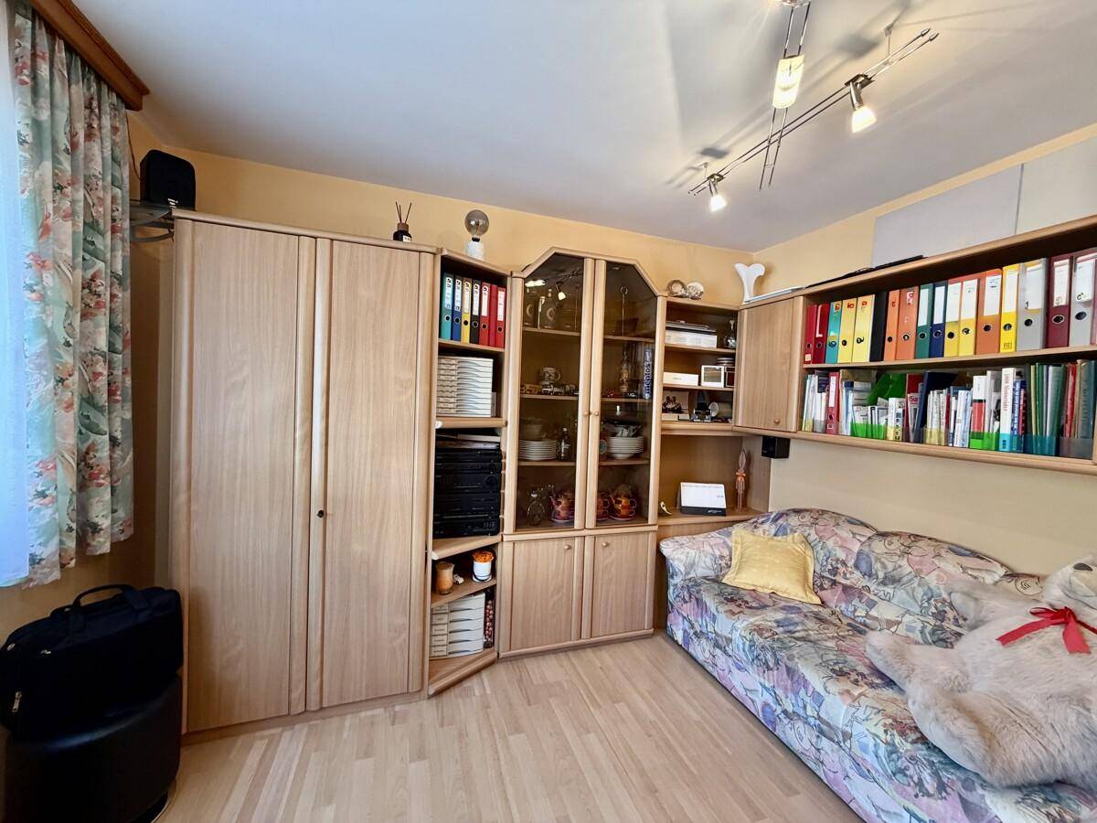 Vielseitiger Raum mit Holzschränken, Sofa und Stauraum für Bücher und Akten.