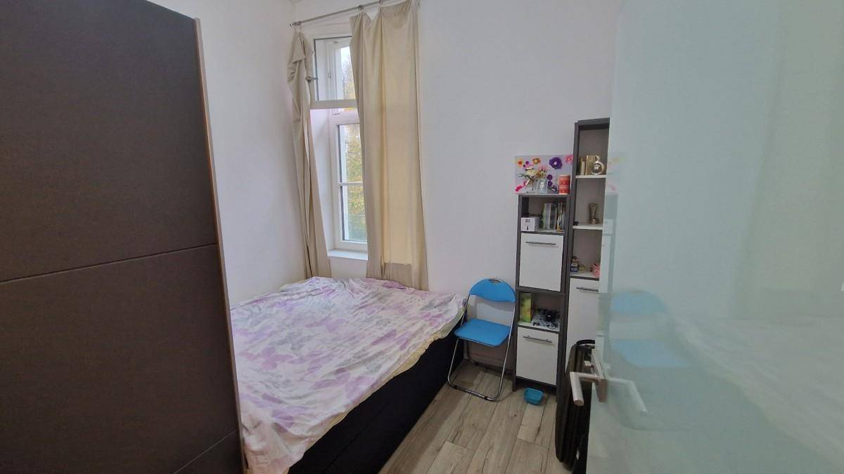 Kleines Schlafzimmer mit Einzelbett, Schrank und Fenster, ideal als Gästezimmer.