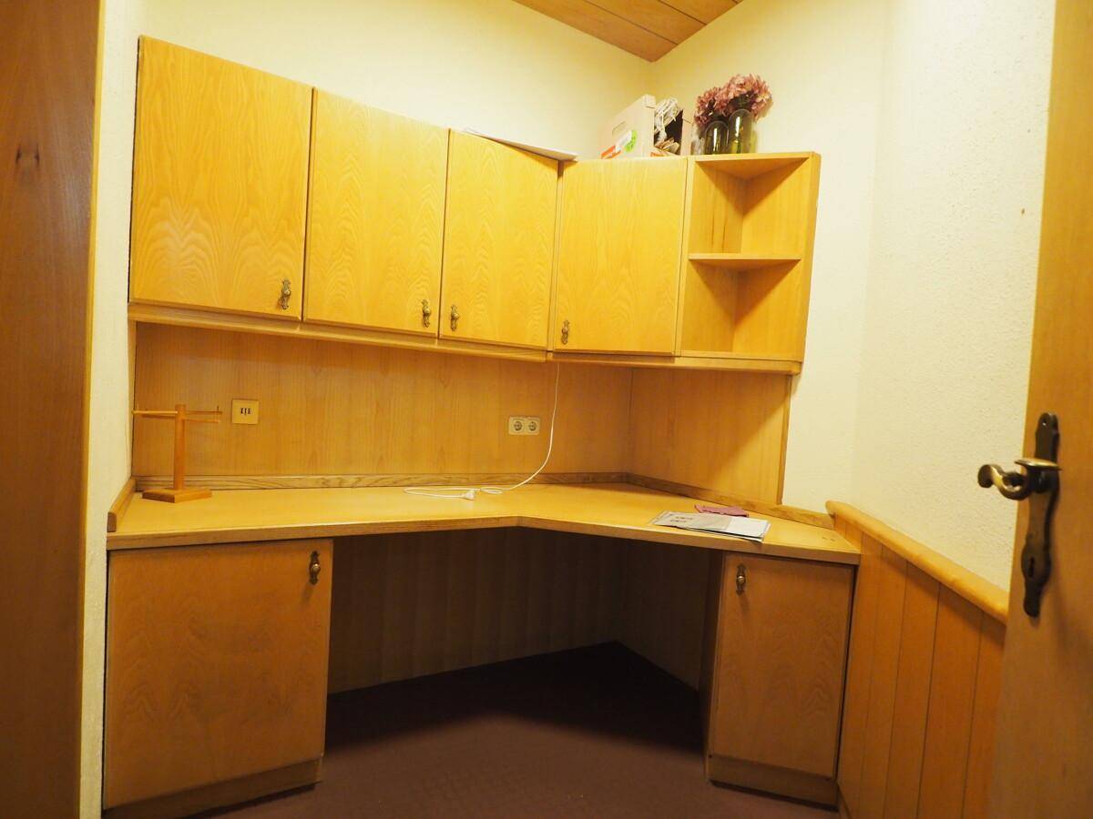 Gemütliches Büro mit eingebautem Holzschreibtisch und passenden Wandschränken.
