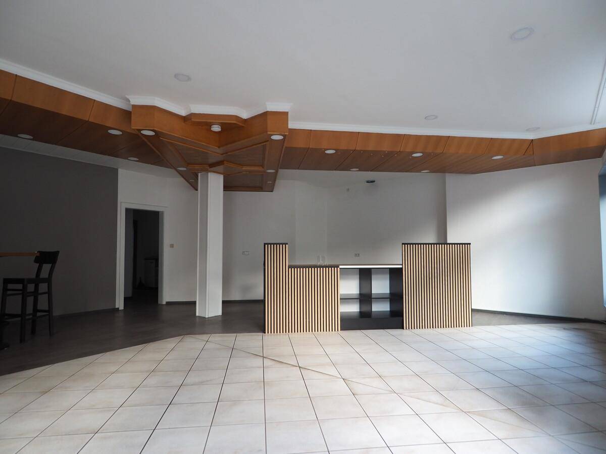 Heller, offener Innenraum mit Holzdeckenverkleidung und einer modernen Theke.