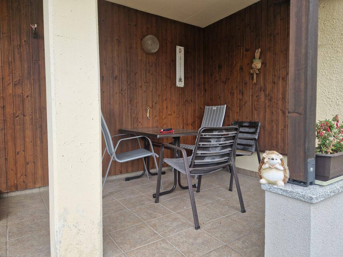 Gemütliche Loggia mit Holzwänden und Sitzgelegenheiten für entspannte Stunden im Freien.
