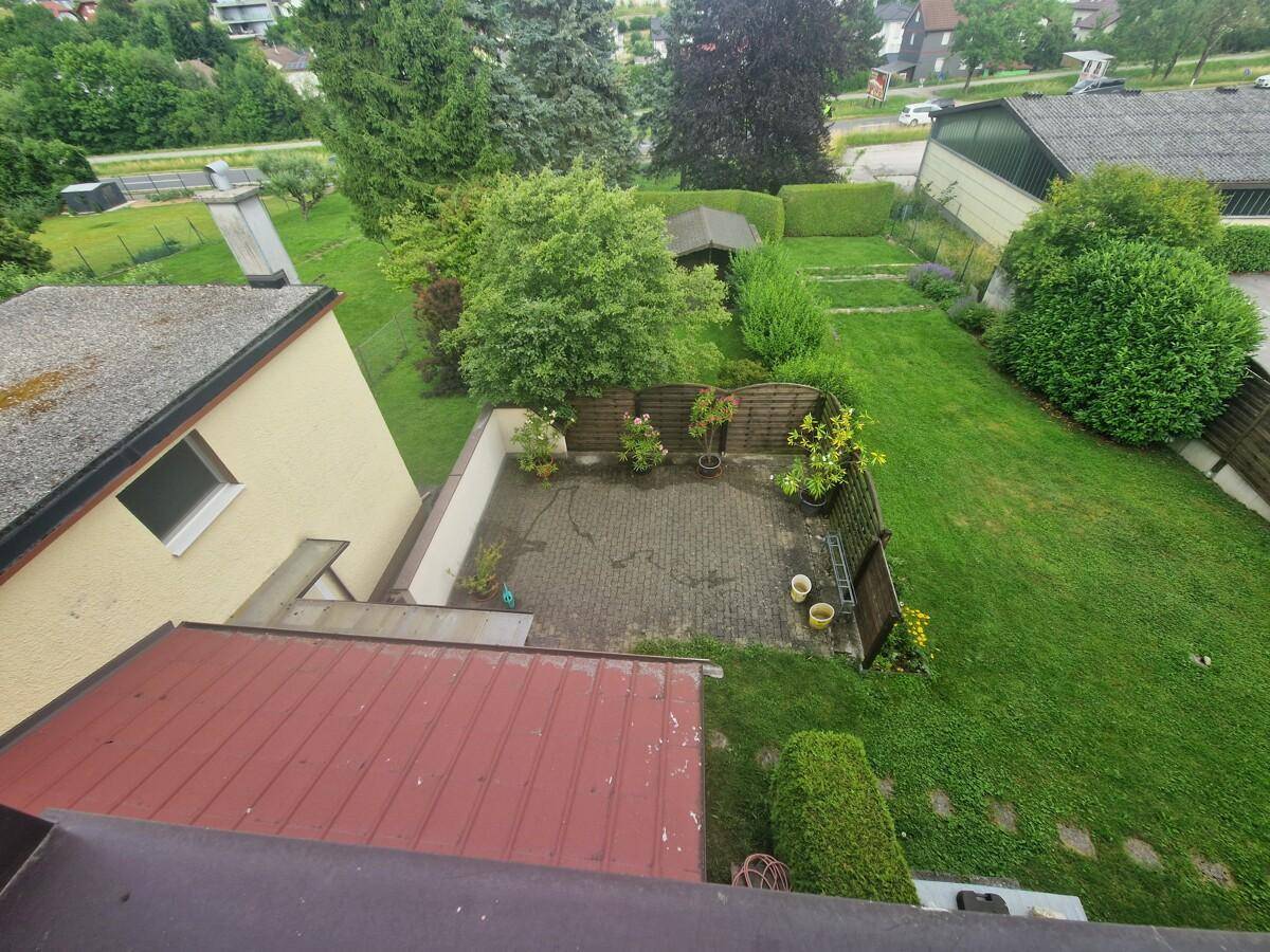 Vogelperspektive des Hauses mit Garten, gepflastertem Bereich und umliegender Landschaft.