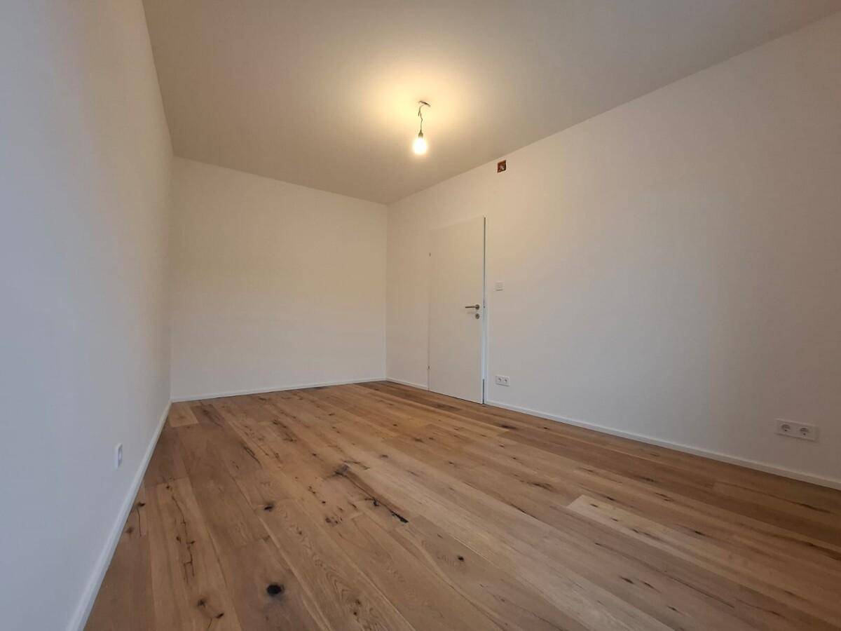 Leerer Raum mit Holzboden und weiß gestrichenen Wänden, bereit zur individuellen Gestaltung.