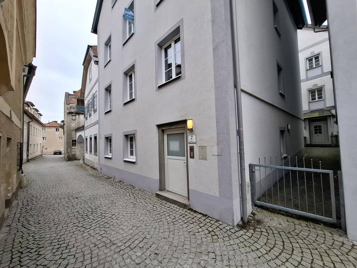 Eingangsbereich eines Gebäudes an einer charmanten Kopfsteinpflastergasse.
