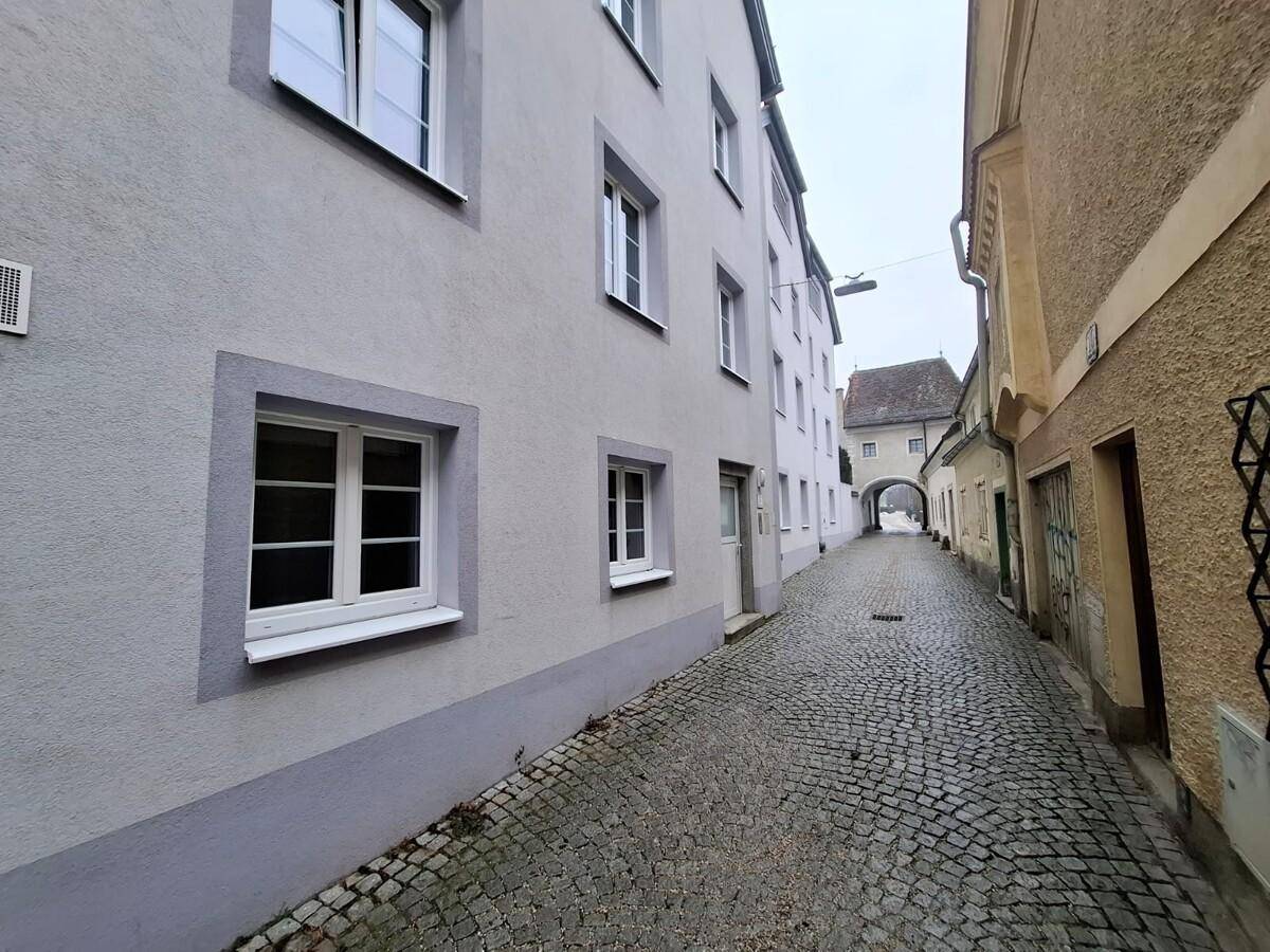 Historische Gasse mit Kopfsteinpflaster und Gebäudefassaden in einer ruhigen Umgebung.