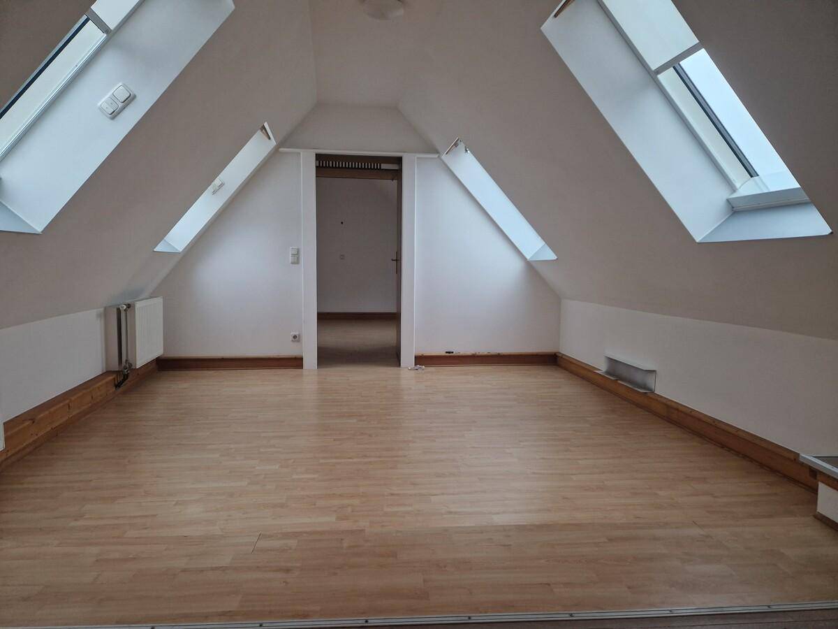 Geräumiges Dachgeschosszimmer mit mehreren Dachfenstern und hellem Holzfußboden, bereit zur individuellen Gestaltung.