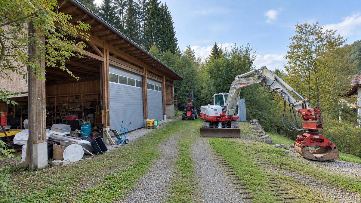 Geräumige Garage mit Rolltoren und verschiedenen Geräten, umgeben von Natur.