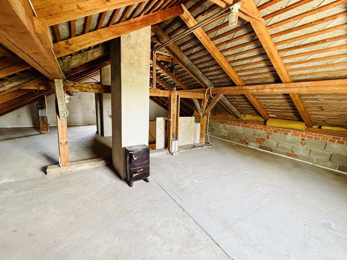 Unausgebauter Dachboden mit sichtbaren Holzbalken, Betonboden und viel Potenzial.